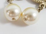 pair of white pearls and gold earrings on a white surface