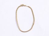 a close up of a gold necklace on a white background