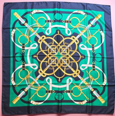 a green and black scarf with a gold and black design