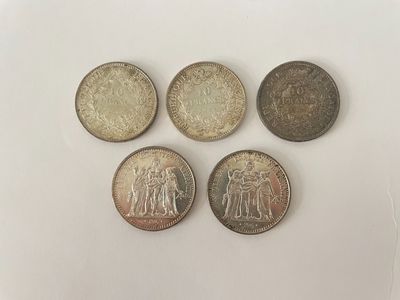 quatre pièces indiennes différentes posées sur une surface blanche
