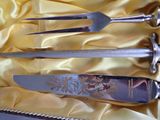 three knives and a fork in a box on a yellow cloth