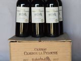 quatre bouteilles de vin rouge sont posées dans une caisse en bois sur une table