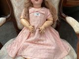 a doll that is sitting on a chair in a room