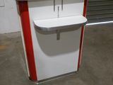 un comptoir blanc et rouge surmonté d'une étagère