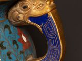 a blue vase with a gold handle and a dragon handle