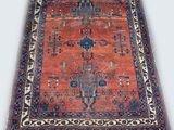 an antique rug with a red and blue design on a white background