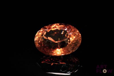 gros plan d'un diamant orange sur une surface noire