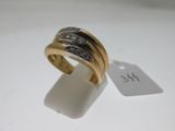 gros plan d'une bague en or avec des diamants sur une surface blanche