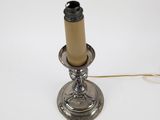 an old fashioned metal candle holder with a candle on top