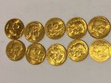 a bunch of gold coins sitting on top of a white surface
