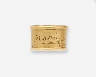 un gros plan d'une bague en or sur laquelle figure une inscription