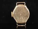 a close up of a gold wrist watch on a black surface