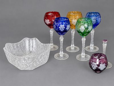 de nombreux verres à vin de différentes couleurs et un saladier sur la table