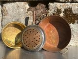 trois casseroles posées sur une table près d'un mur de pierre