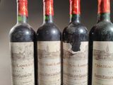 three bottles of red wine are lined up on a table