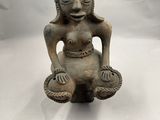 un gros plan sur la statue d'une femme assise sur une surface blanche