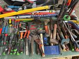 many different tools on a table with a car in the background