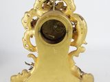 a gold clock with a gold decoration on top of it