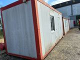 a red and white container sitting outside of a building