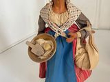 a figurine of a woman with a hat and a bag