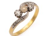 un gros plan d'une bague en or ornée de deux perles et de diamants