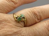 la main d'une femme tenant une bague sertie d'une pierre verte