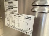 a stainless steel refrigerator with a sign on the door