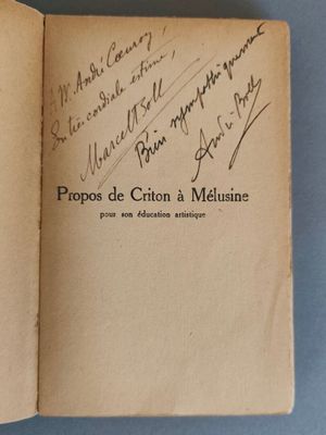 un livre ouvert avec une écriture dessus, posé sur une table