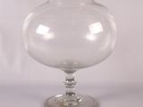 un vase en verre transparent avec un socle transparent posé sur une table