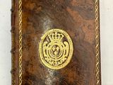 un vieux livre relié en cuir, orné d'un médaillon doré sur la couverture