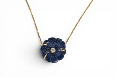 a blue flower pendant with a diamond on a gold chain