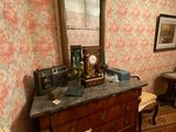 a dresser with a mirror on top of it in a room with floral wallpaper