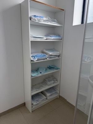 une salle de bains avec une paroi de douche en verre et une étagère avec des serviettes