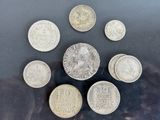 six different coins are arranged in a circle on a black surface