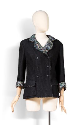 veste en tweed noir sur un mannequin de vitrine, avec un col multicolore