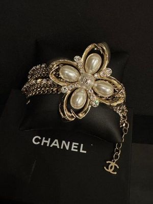 un gros plan sur un sac orné d'une broche en forme de fleur