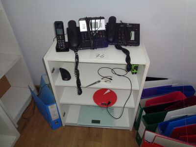 une étagère blanche sur laquelle sont posés plusieurs téléphones