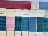 several books are lined up in a row on a white surface
