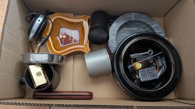 une boîte en carton remplie d'objets hétéroclites sur le sol