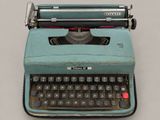 an old typewriter sitting on a table with a gray background