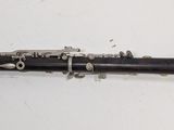 a black and silver clarinet sitting on a white surface