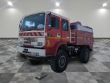 un camion de pompiers rouge garé sur un sol à damier