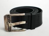 une ceinture noire ornée d'une boucle argentée sur un fond blanc