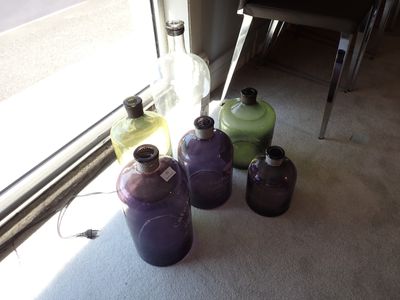 de nombreuses bouteilles de liquide posées par terre près d'une fenêtre