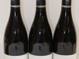 trois bouteilles de vin sont alignées sur une table