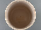 a brown cup with a brown lid sitting on a table