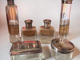 four glass containers with silver lids on a white surface