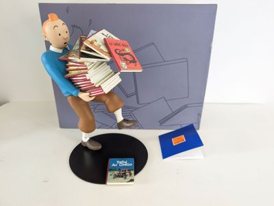 une figurine représentant un homme tenant une pile de livres
