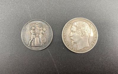 two silver coins, one of which has a bust and one of which is a bust
