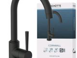 un gros plan sur un robinet noir avec une boîte en arrière-plan